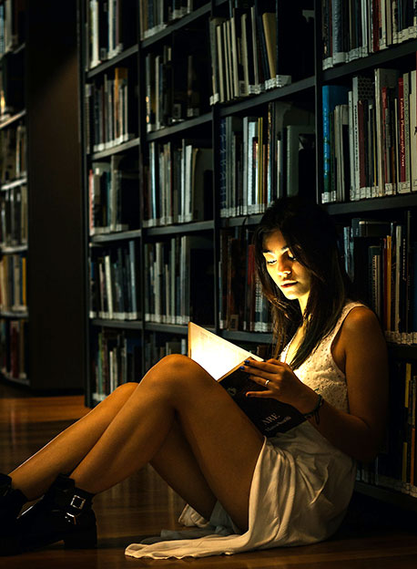 Mujer disfrutando de la lectura en una biblioteca